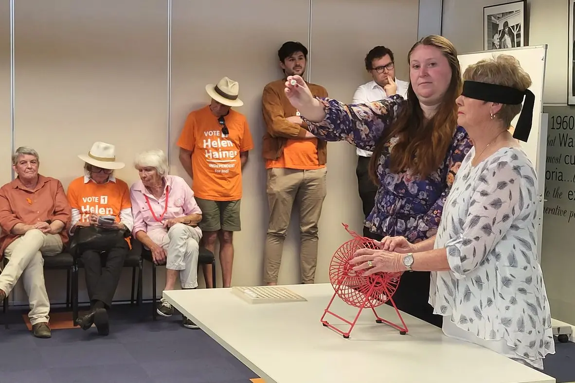 SEE THE NUMBER: An AEC representative draws out one of nine numbers and shows the audience.