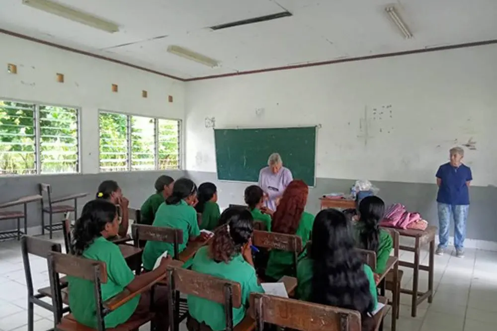 PRACTICAL ASSISTANCE: Barbara Broz distributes menstrual kits to school girls, made by a volunteer team in Myrtleford, which will help them be able to spend more time at school.