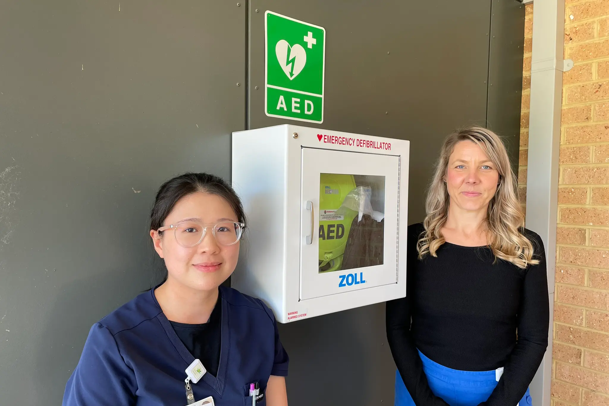 <p>SET TO SHOCK: Graduate registered nurse Zen Tan (left) and director of clinical operations at Myrtleford, Lisa Townsend, are pictured with the recently installed AED at the main entrance of the Myrtleford Hospital. PHOTO: Alpine Health</p>\\n
