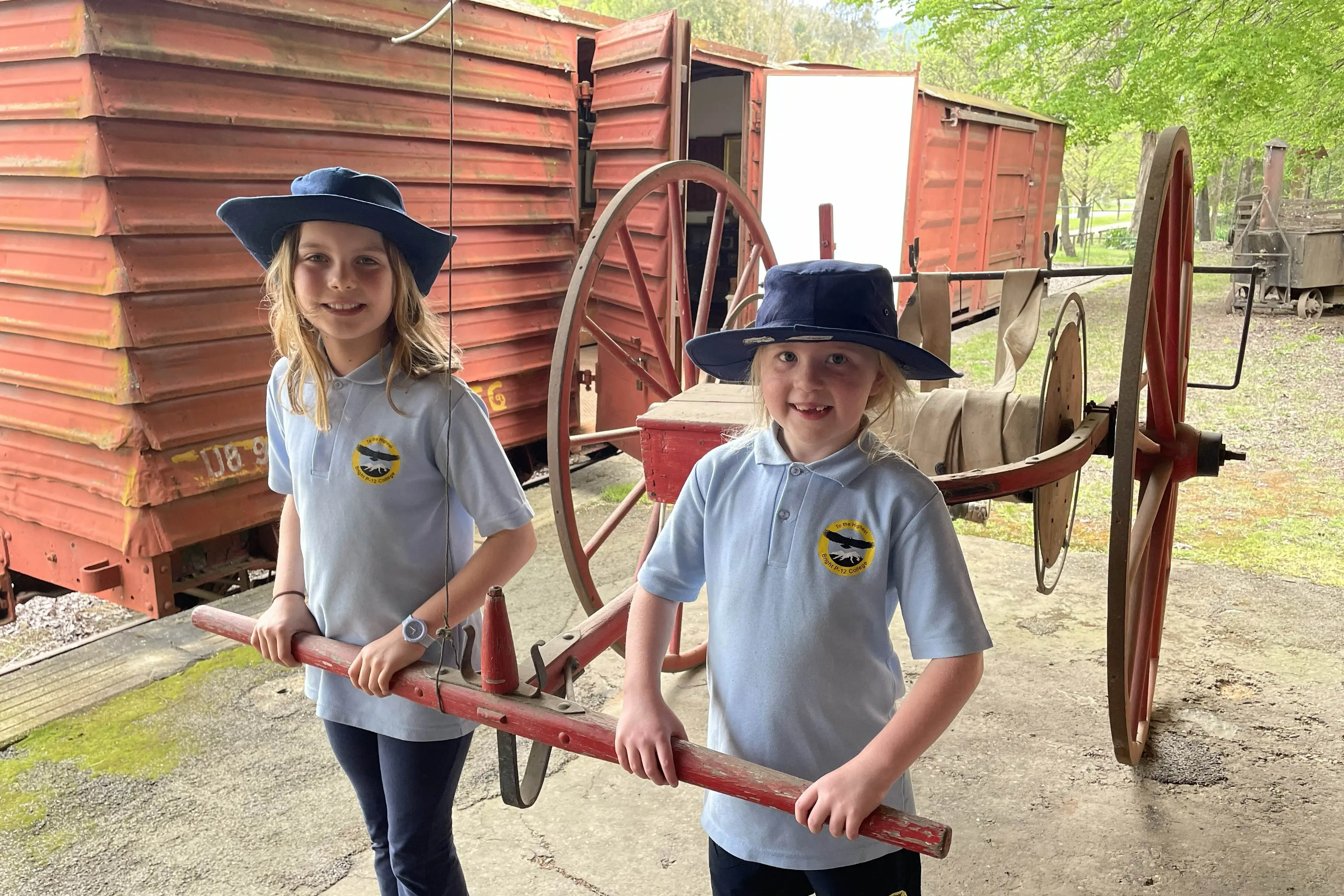<p>FIREFIGHTERS: Checking out the fire brigade\\'s old hose and water cart were Tilly Gray (left) and Annabelle Wilson.</p>\\n