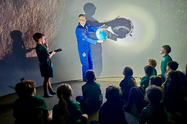 <p>OUT OF THIS WORLD: Porepunkah student Toby Carton (left), aka \\u2019The Sun\\u2019 shines light on the Earth to the rapt attention of fellow students.</p>\\n