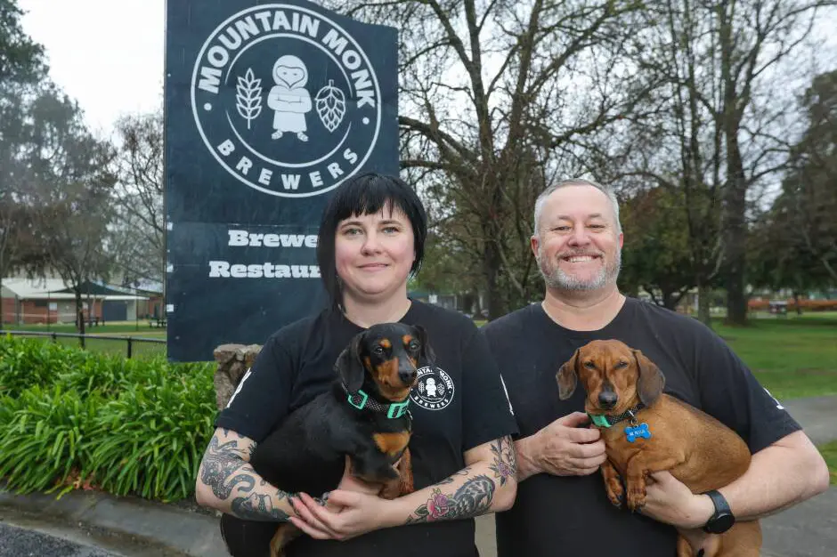 <p>READY TO RACE: Mountain Monk proprietor Stephanie Bellman and sales manager Joshua Grocke with two hopeful racers looking forward to competing in the Dachshund Derby on Saturday 3 October.</p>\\n